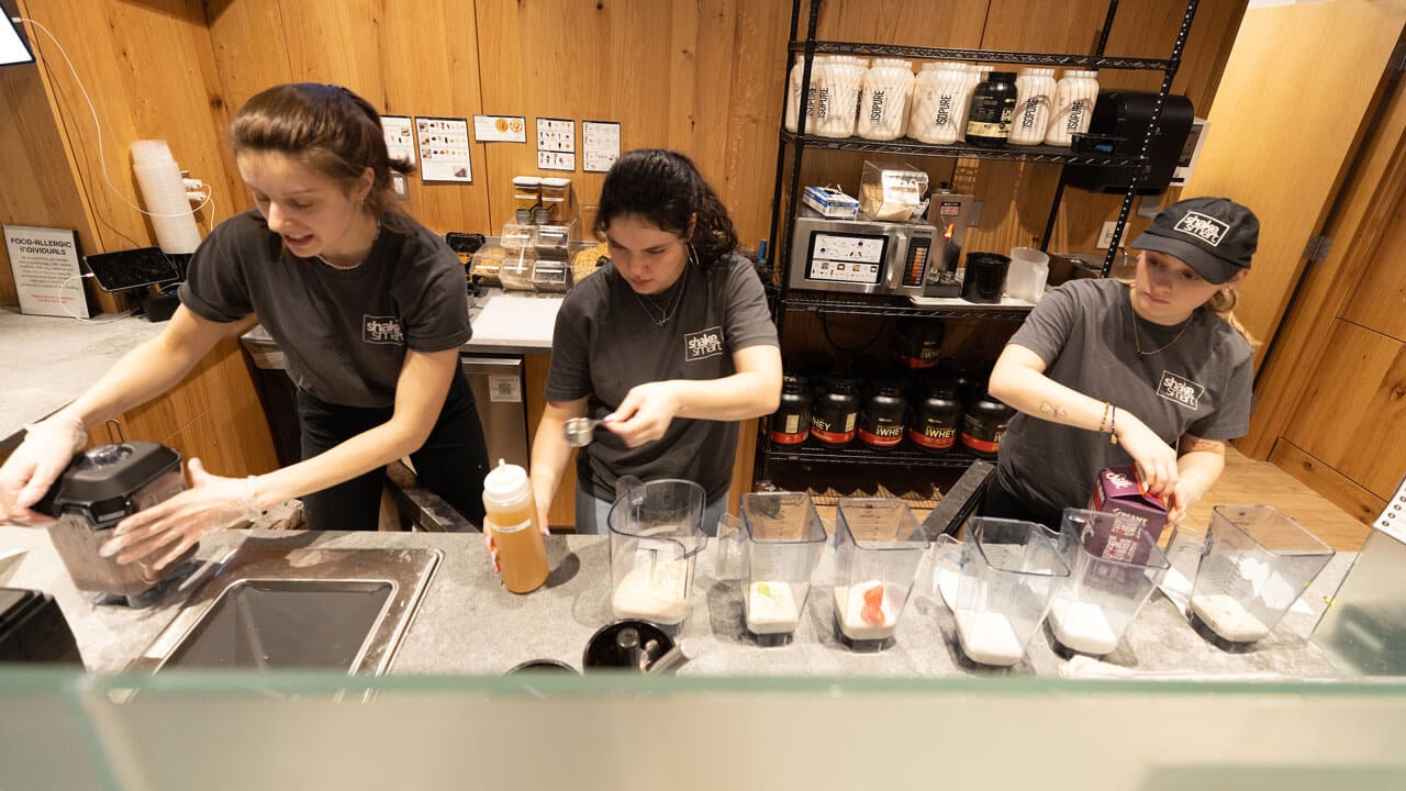 Shakesmart workers make smoothies during rec and wellness opening.