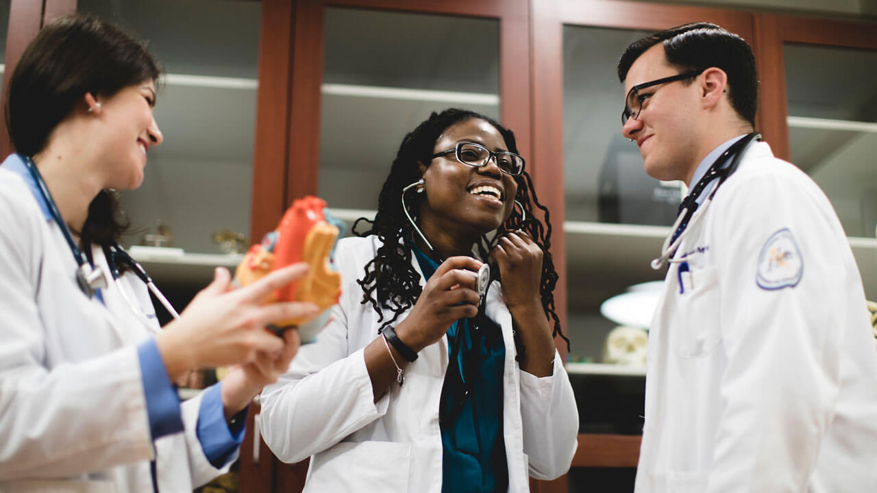 School of Medicine students smile wearing stethoscopes.