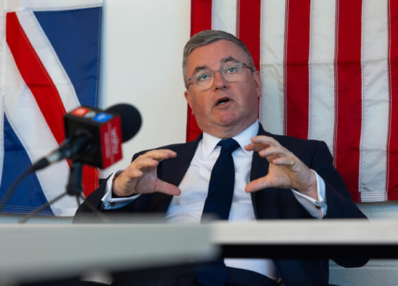 Robert Buckland sits at a table with a microphone