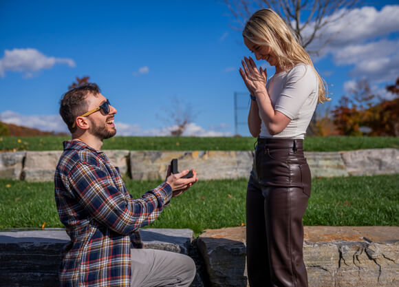 Two people getting engaged at surprise proposal