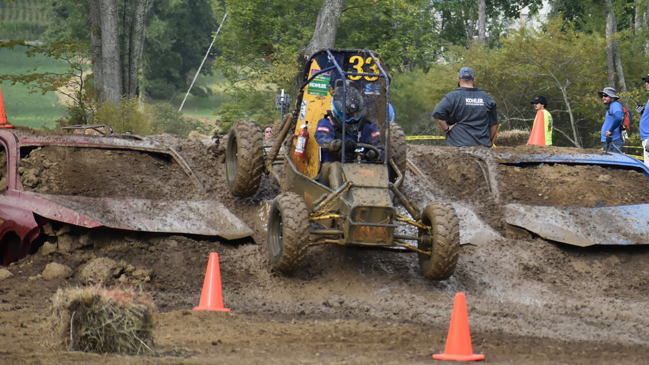 The Baja vehicle driving down a steep, muddy hill