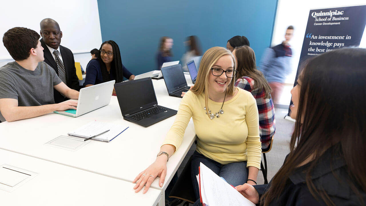 Students sit around a table in a classroom