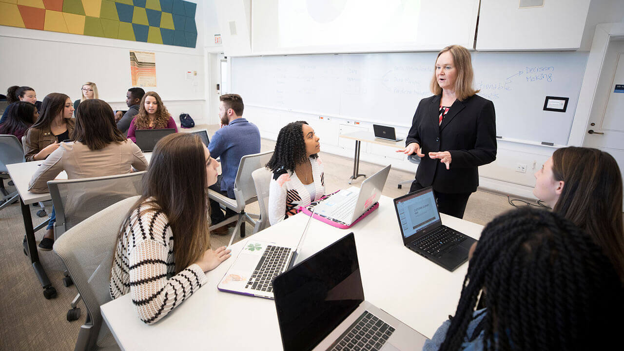 A professor lectures in a classroom in the School of Business