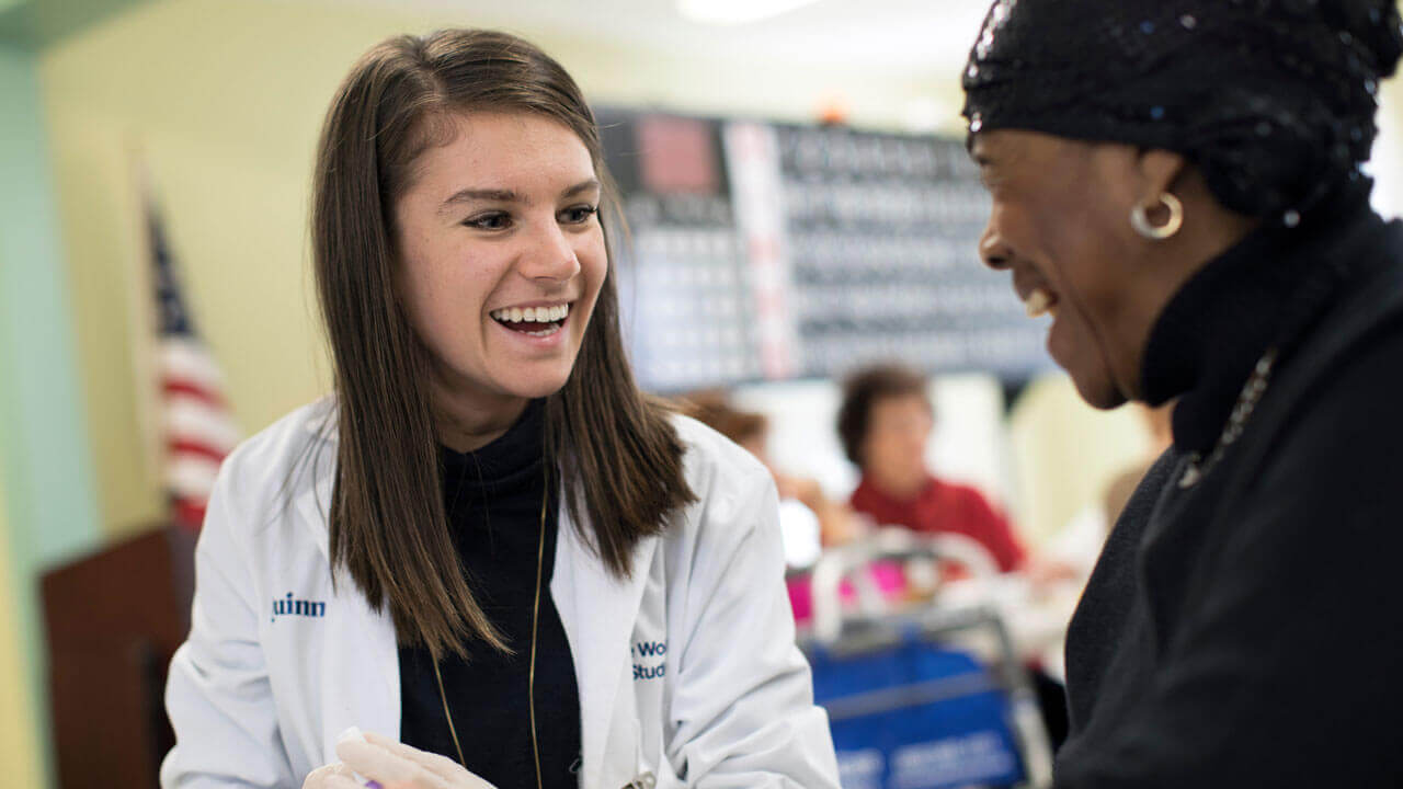 Student performs a blood glucose test for patient during a health fair