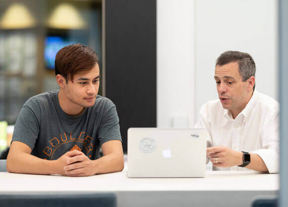 A student working with staff in the Advising Commons.