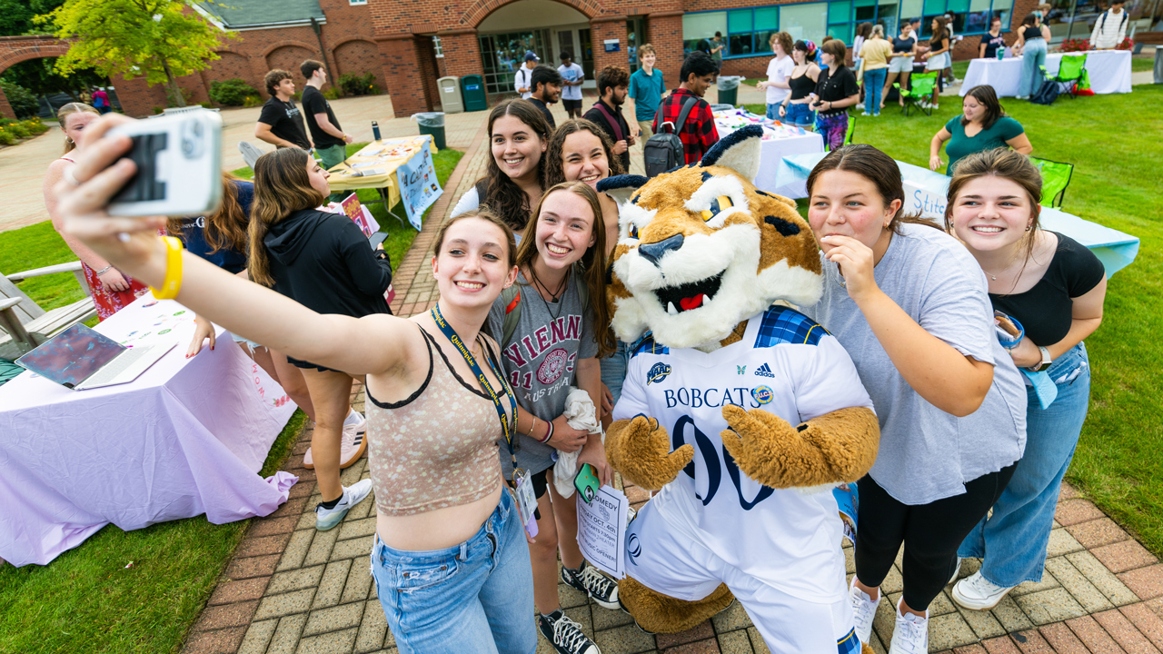 Students take a selfie with Boomer the mascot